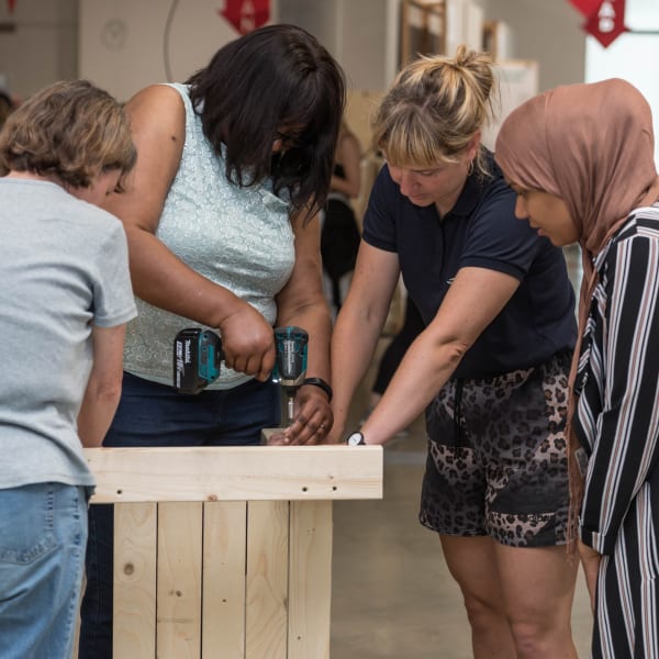 A group of women working with a drill