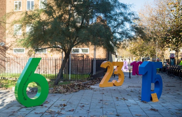 Art exhibit featuring large numbers on a paved road