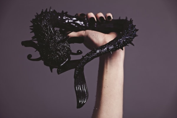 Black glittery dragon held by a hand