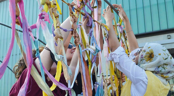 People threading ribbons