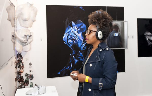 Girl wearing headphones at a private view event