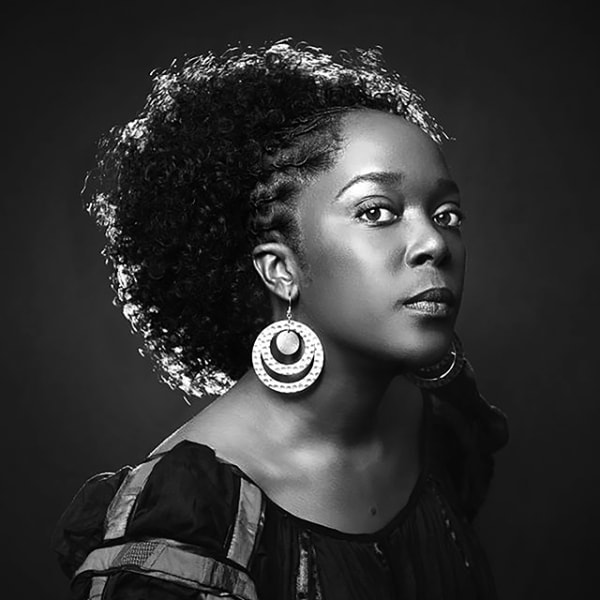 Black and white portrait of Lesley-Ann Noel looking at the camera from the side