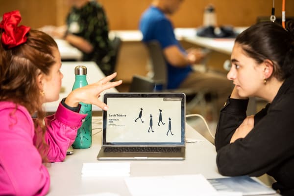 Two people looking at a laptop