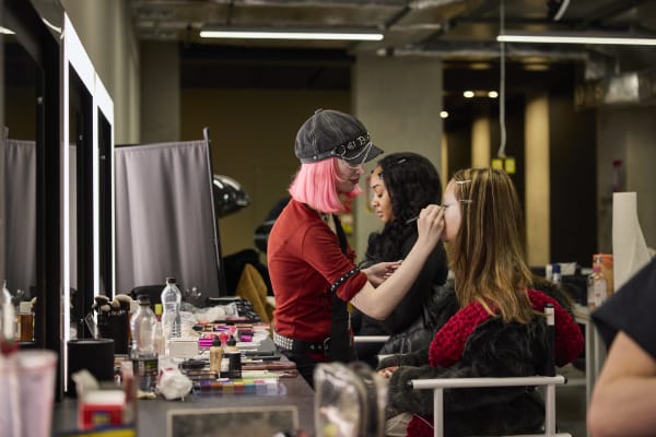 Makeup student painting a model