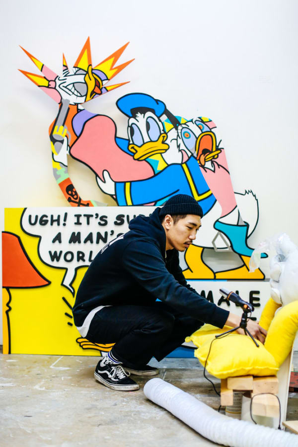 Man crouched in front of artwork. BA (Hons) Fine Art, Shinuk Suh in the Studio, Copyright holder: Alys Tomlinson