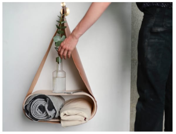 A vase and two rugs on a shelf 