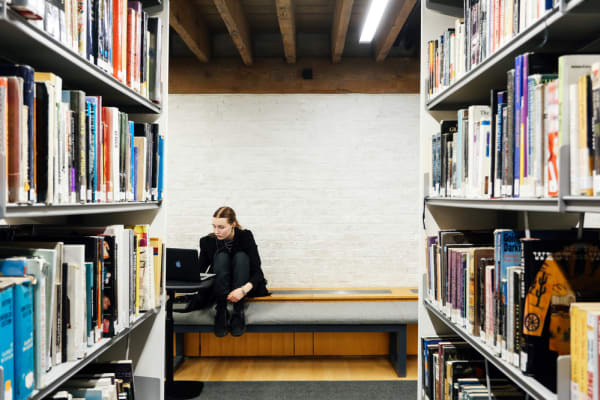 Woman sat on a bench in the library. Working in the library, Copyright holder: Alys Tomlinson
