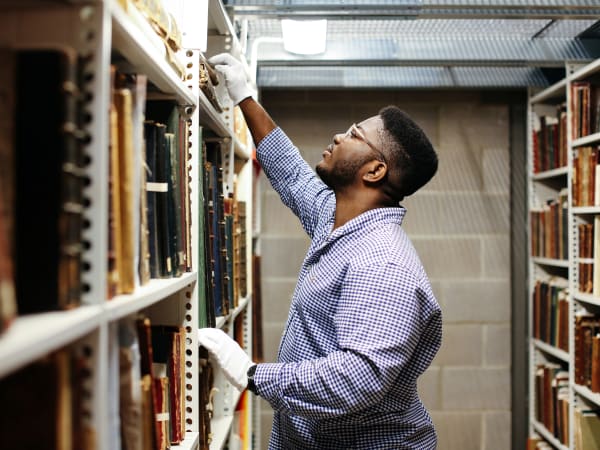 Student reaching for object on high shelf.