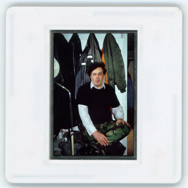 A-Polaroid-picture-of-a-man-posing-in-front-of-hung-jackets.jpg