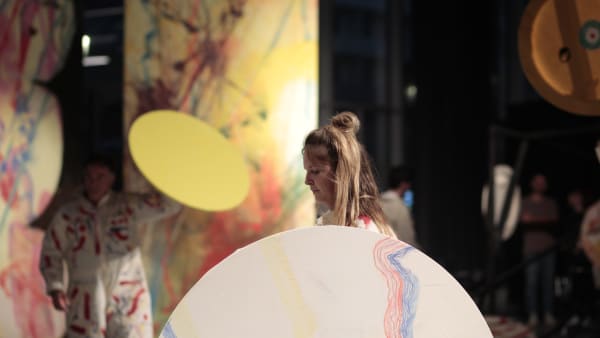 Student performing with a large circular painted prop