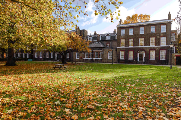 Exterior shot of Portland House, a Victorian brick building with a large grass courtyard