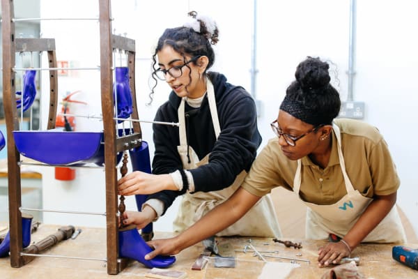 Two students creating a wooden structure