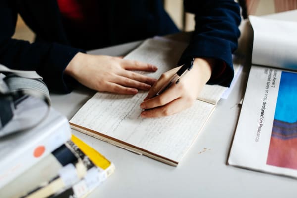 Woman writing on paper, BA (Hons) Culture, Criticism and Curation, Rebecca Derine in the studio, Case study, Copyright holder: Alys Tomlinson