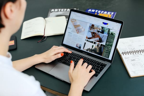 Student sitting at a desk using a computer to design creative media artwork