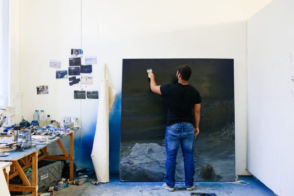A man painting on canvas.