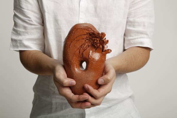 Person holding a piece of ceramic art
