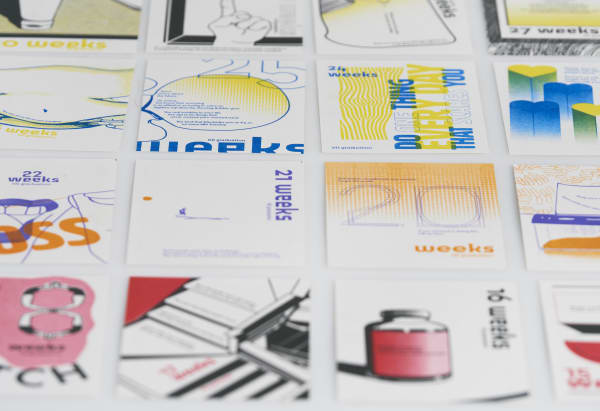 A collection of visually diverse, creatively designed posters arranged in a grid, each labeled with a specific number of weeks remaining until graduation.