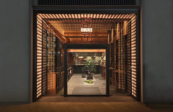 A large square entrance to a restaurant which is lit up by lots of lights around the door