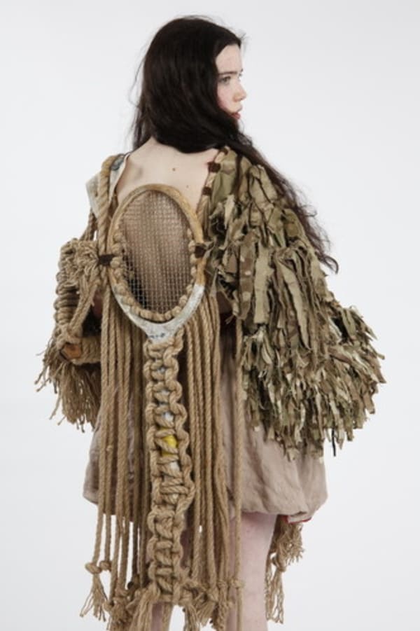 Girl in a large brown garment with lots of texture and big sleeves