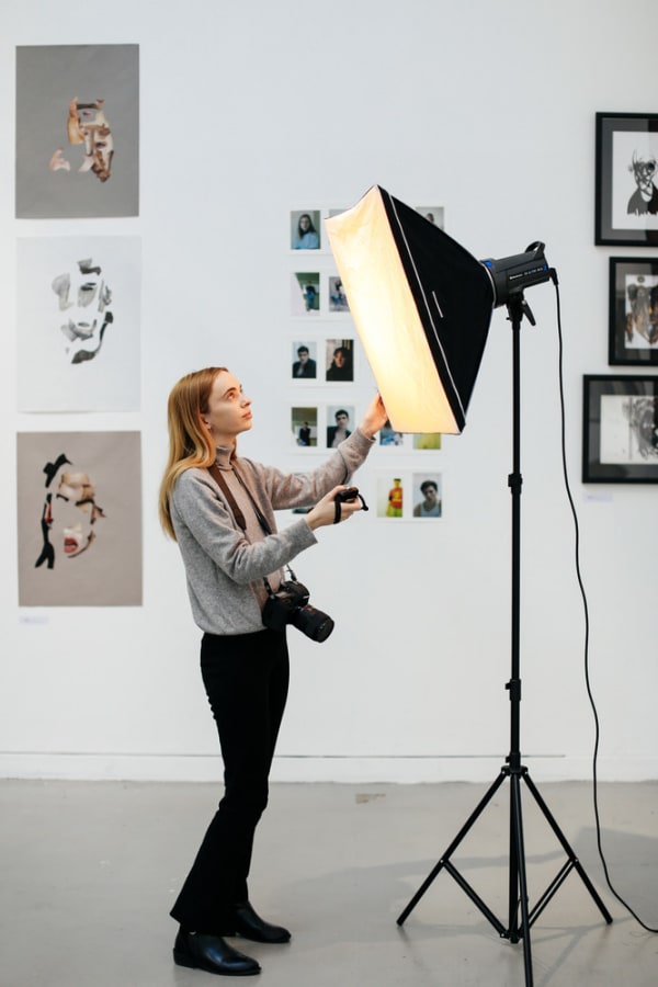 Female student adjusting a large softbox light.