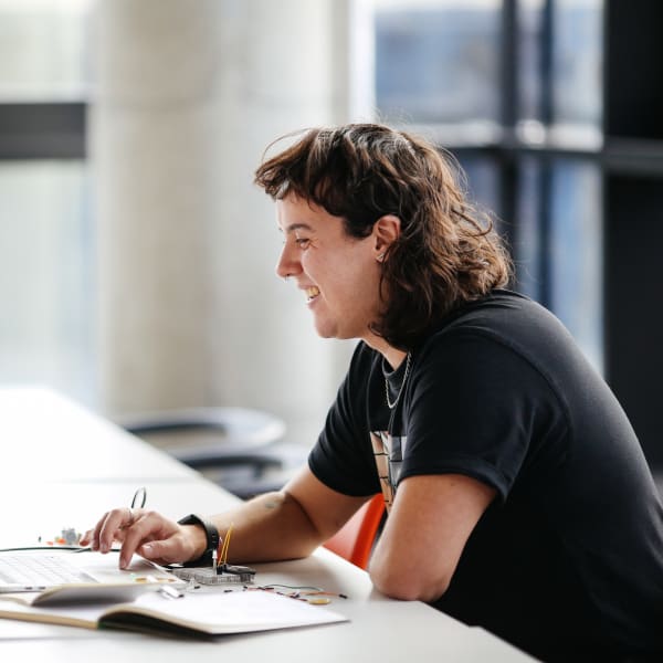 Finn Weaver smiling at their laptop