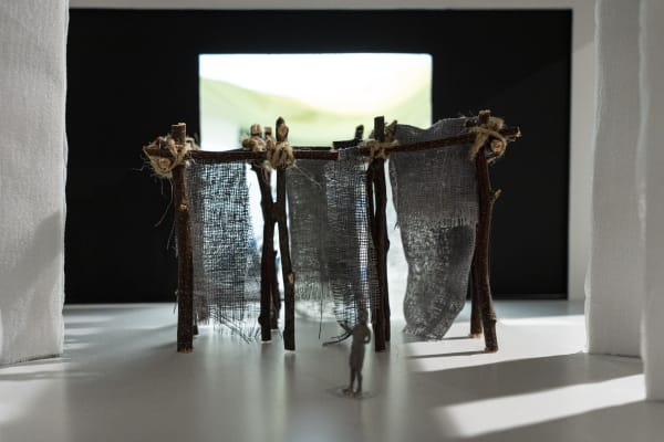 A model structure of walls held by wood, fabric and string