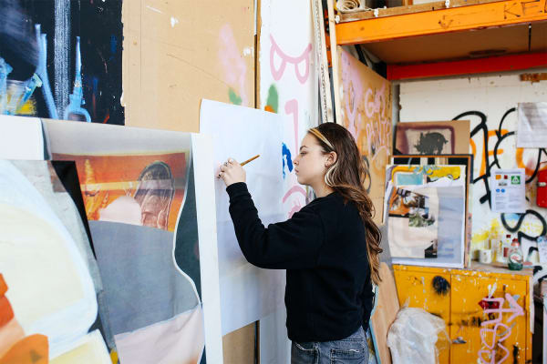 Student painting on large canvas in studio