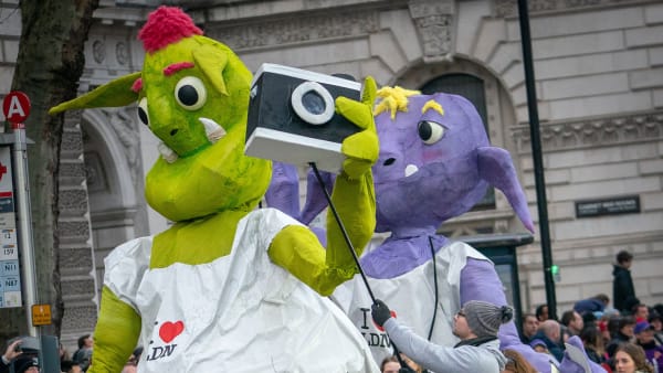 Two large alien puppets, one green and one purple.