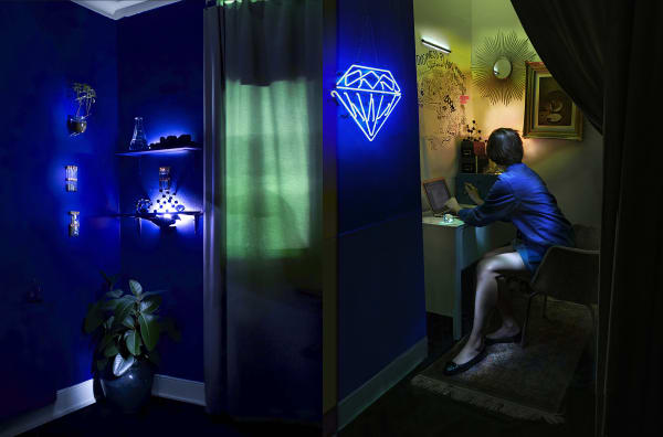 Female working in makeshift lab. Dark blue and neon lighting.