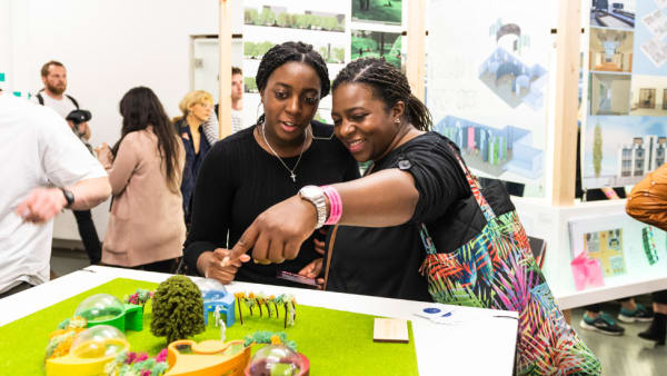 Two women facing the camera looking at an exhibition