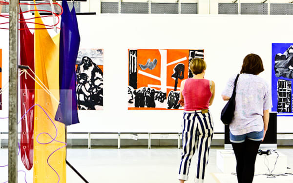 Two people looking at art in a gallery