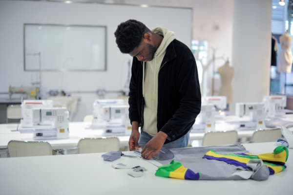 Student constructing their fashion piece in a production room.