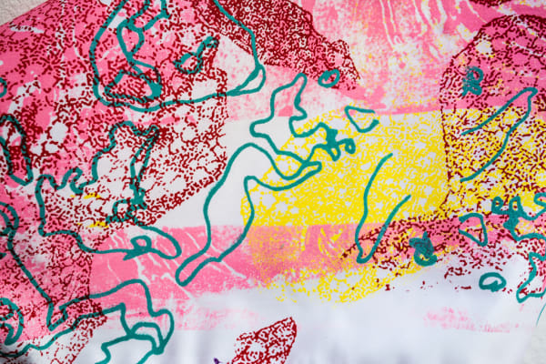 Pink, yellow and green abstract pattern on white fabric