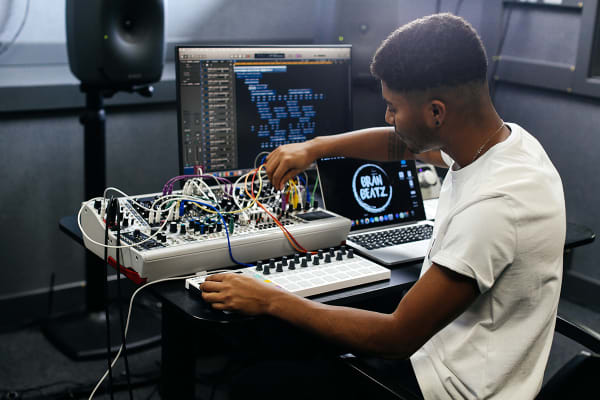 Student sitting at a sound music mixing desk 