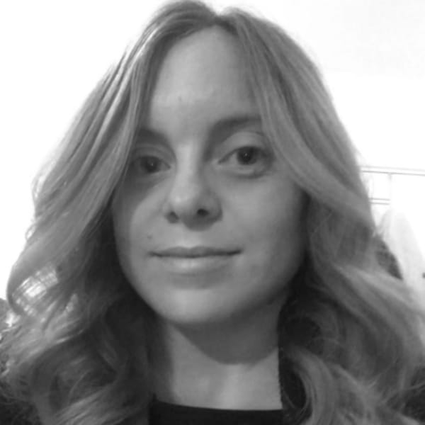 Amy Hulme, FTTI Project Manager is smiling at the camera, with mid length blonde hair, the image is black and white with a white background. 