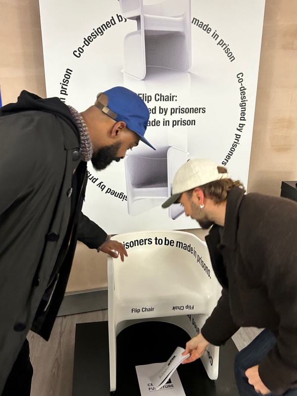 Exhibition visitors engaging with a poster of the Flip Chair design at Making Time.