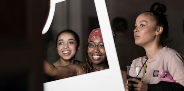 Photo of three female students posing with a giant photo frame