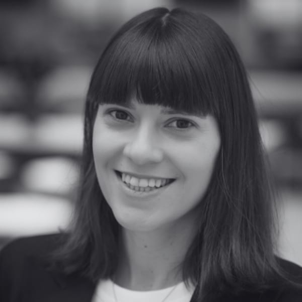 Natalie Nestorowicz, a white woman with brown eyes and straight, medium length brown hair smiling at the camera
