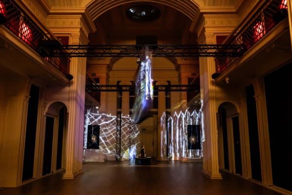 A dark room with a rotating screen alternatively plays two videos