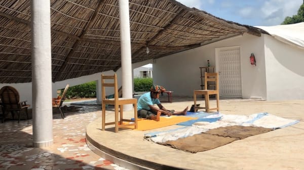 someone sitting in the sun under a canopy