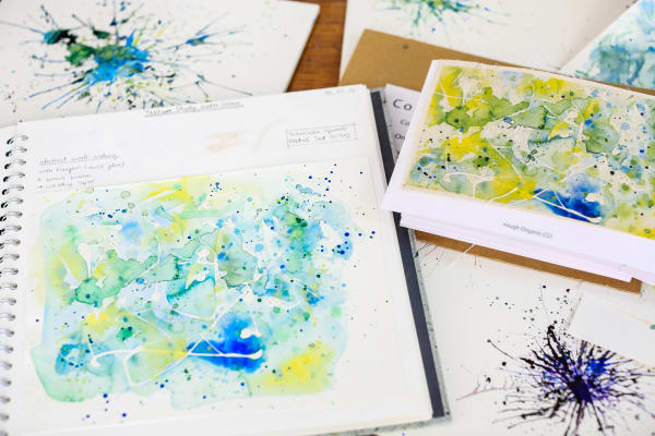 Sketchbook with splashes of paint on them.
