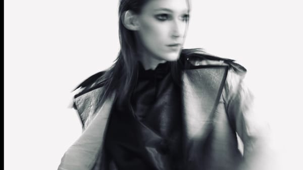 Black and white image of female model with blurred, soft clothing.
