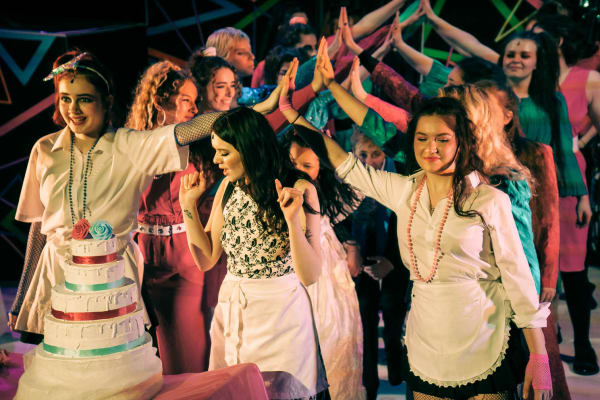 Image showing a performance with students on stage, in a wedding setting, dancing together