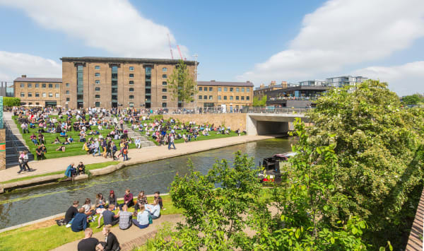 Lots of people sat on steps and on an open square