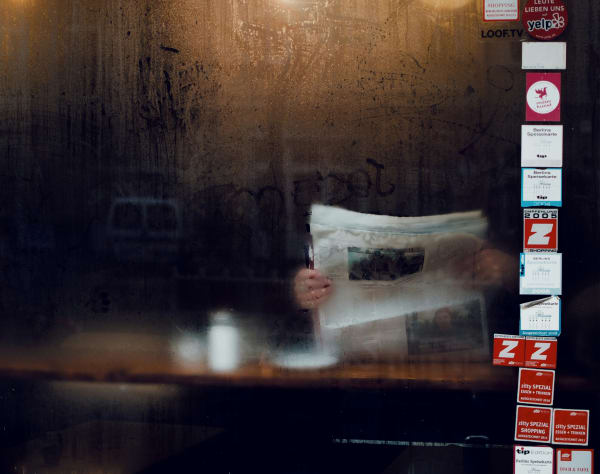 a blurry photo of someone reading a newspaper