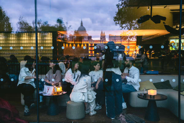 Photo from outside looking in - busy bar with St Paul's Cathedral reflected in the top of the window