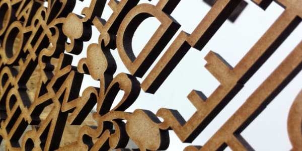 Rear view of wooden cut out letters against white background