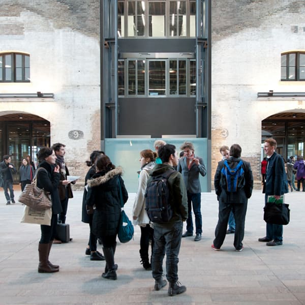 Visitors looking around the entrance of Central Saint Martins which is set in a Victorian grain store