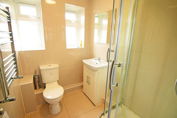 Shared bathroom at Cedars Hall, with shower, sink, toilet, mirror and heated towel rack