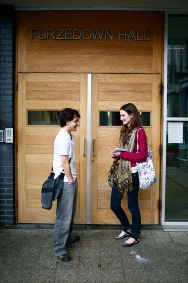 Photo of two students standing outside the entrance to Furzedown Student Village